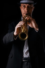 Fototapeta na wymiar soprano saxophone in the hands of a guy on a black background