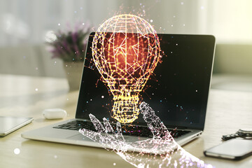 Fototapeta na wymiar Creative light bulb hologram on modern laptop background, idea concept. Multiexposure