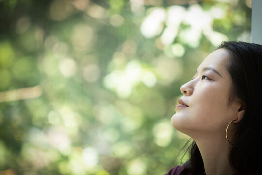 Profile serene young woman looking out window