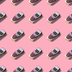 Retro mobile phone on a pink background. Seamless pattern.