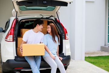 Happy aisan couple help moving cardbord boxes to new house together. Moving day.