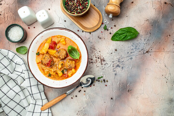stewed vegetables with meatballs in a white bowl, place for text, top view