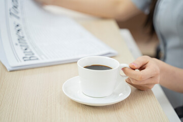 Businesswoman at the office holding a cup of coffee in the morning.