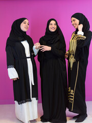 beautiful muslim woman in fashinable dress with hijab isolated on modern plastic pink background in studio representing concept of modern islam and ramadan kareem