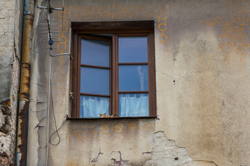 Red domestic cat sleeps on a windowsill on an old street in Lublin, Poland