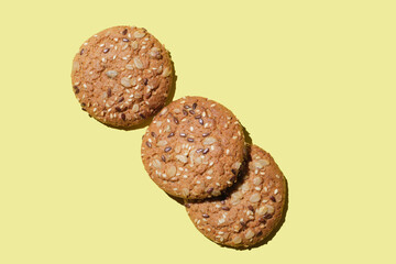 Dietary oatmeal cookies with  seeds on yellow background.