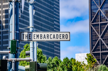 Street name sign for The Embarcadero in San Francisco, California, USA with tall, modern buildings in the background.