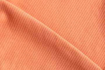 Folded ribbed cotton fabric texture pastel orange  . Close up rib cotton cloth and textiles...