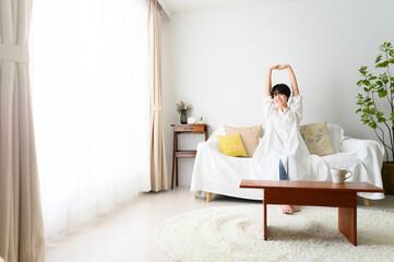 Woman stretching comfortably in her room Wide angle