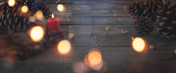 Burning candle for christmas, dekorated on dark wood with fairy light and pine cone. Background...