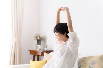 Obraz na płótnie Canvas Woman stretching comfortably in her room, profile