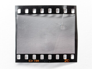 creased 35mm filmstrip isolated on white paper background, blank or empty film material.