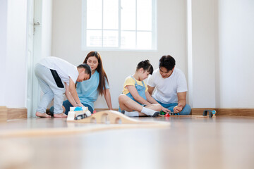 Happy asian family playing wood block create rail road  together at home