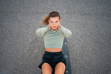 Sit-ups exercises. Active, fit sporty woman doing situps, exercising and training for fitness outdoor gym