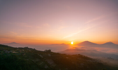 Sunrise over mountain with view of village on the slope of Mountain. Mangli Village on the slope of Sumbing Mountain