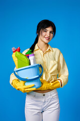 woman in gloves holding bucket with cleaning supplies