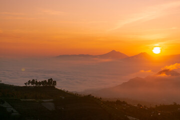 Sunrise over mountain with view of village on the slope of Mountain. Mangli Village on the slope of Sumbing Mountain
