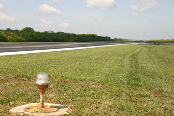 A white runway light in grassy area