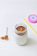 Morning healthy breakfast. Cocoa milk and oatmeal granules. Wooden white background.