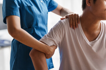 Obraz premium Physical therapist is examining the injured arm, waist and neck muscles of an athletic male patient.