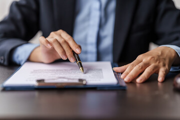 Cropped image of female lawyer reading and signing contract.