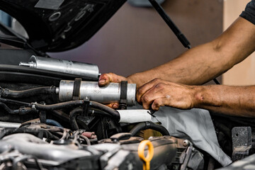 Obraz na płótnie Canvas Close up of auto mechanic repairing car engine in car service