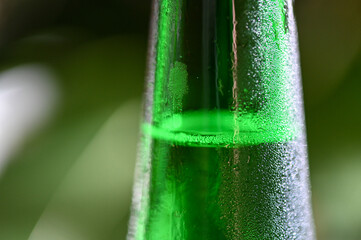 Closeupd of cold green wine bottle with water drops 
