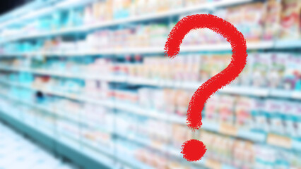Large red question mark on blur supermarket background. Defocused shelves with food product....