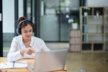 woman using a computer and earphone during a video conference