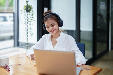 Fototapeta premium woman using a computer and earphone during a video conference