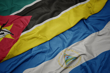 waving colorful flag of mozambique and national flag of nicaragua. 3d illustration