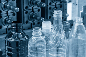 The various type of plastic bottles with injection mold background.
