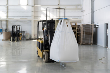 forklift transports heavy bulk cargo in a large white bag © Дмитри Лобакин