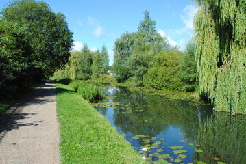 Fototapeta na wymiar View of Canal and Towpath on Sunny Day