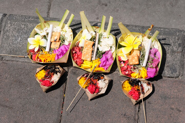 Hindu religious and cultural food and flower offering on the pavement in Bali, Indonesia
