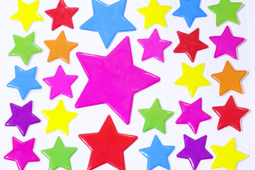 Multi-colored star stickers are pasted onto white handmade paper.