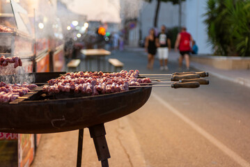 man roasting meat skewers on the street during a folk festival in italy