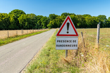 Panneau de signalisation sur une route de campagne : présence de randonneurs