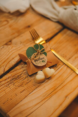 a small gift for guests for a holiday on a table made of cardboard soap inside with a name plate fork vintage