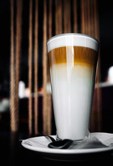 Glass cup of coffee Latte macchiato on table in cafe