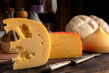 Varied cheese table, blue cheese Fontina Gruyer Cheese Teetilla in wooden table with red wine glass...