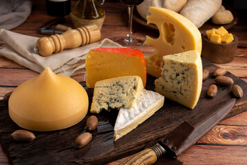 Varied cheese table, blue cheese Fontina Gruyer Cheese Teetilla in wooden table with red wine glass...