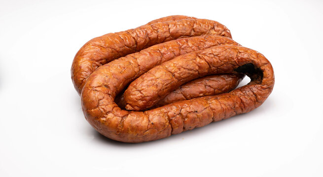 Rings of country style smoked sausage, isolated on a white background. Traditional Polish meat sausage, packshot photo.