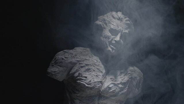 A white statue of a man. A close-up shot on a black background.