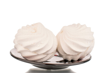 Two sweet white marshmallows on earthenware, macro, isolated on white background.