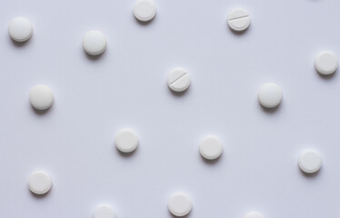 Many white tablets or pills on a white background. Medical pharmacy and medicine concept with copy space. Scattering of white round pills. High quality photo