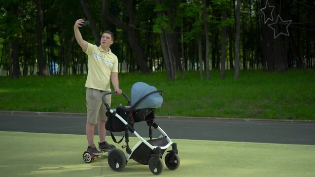 A young dad walks in the park with a stroller
