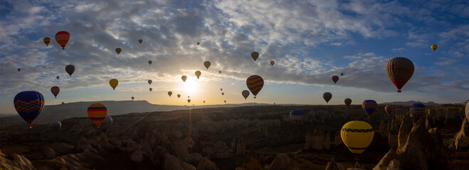 Balloons flying in Cappadocia, Göreme at sunrise. Cappadocia is known around the world as one of...