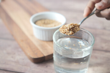 mixing flax seeds in glass of water 