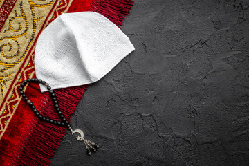 Black Muslim rosary with silver crescent moon near prayer rug
